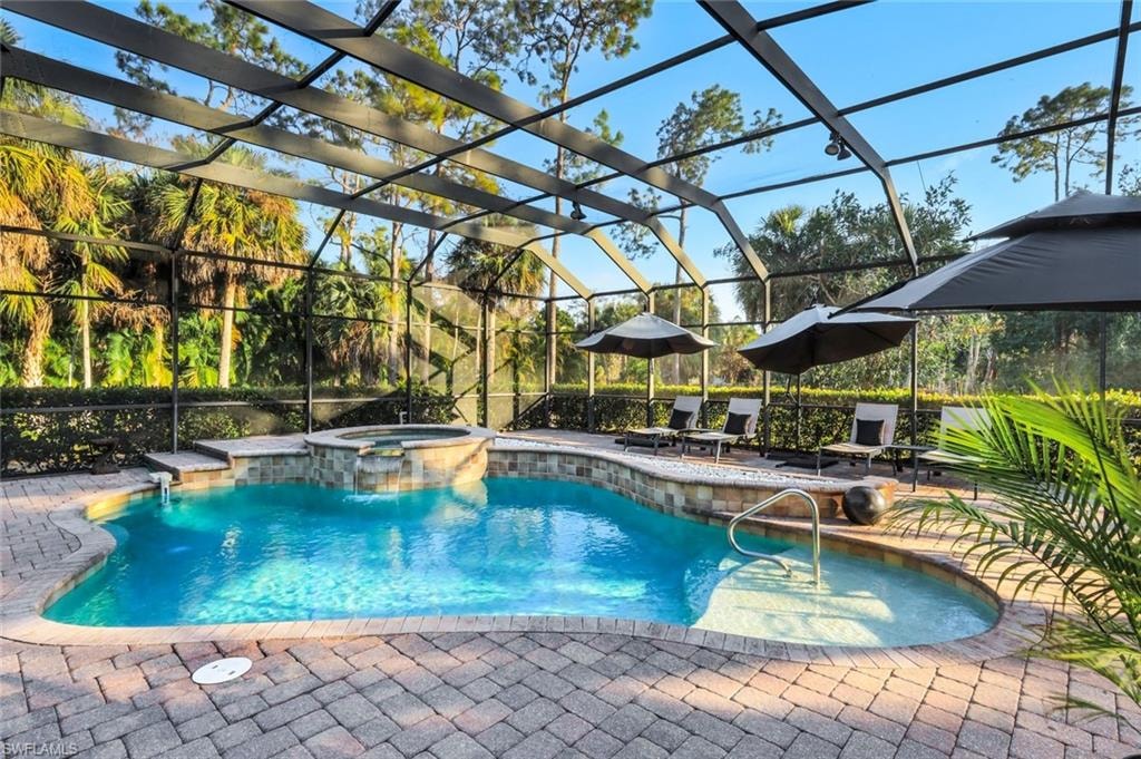 Relaxing pool / spa with glass enclosure and a patio