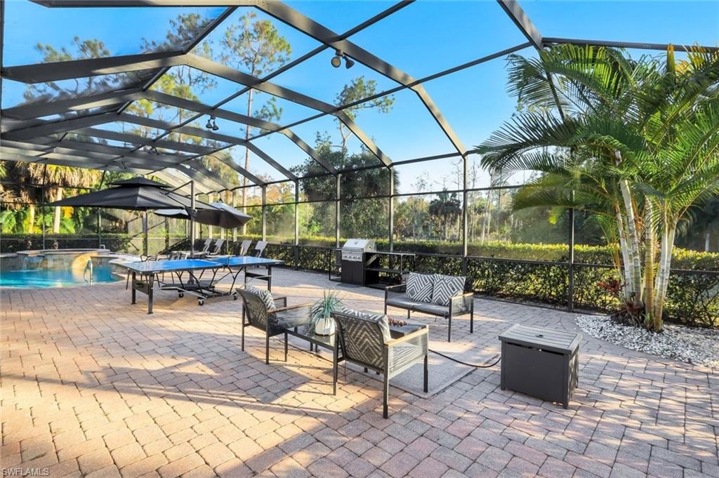 View of patio / terrace featuring glass enclosure, an outdoor lounge area, an outdoor pool, and area for grilling