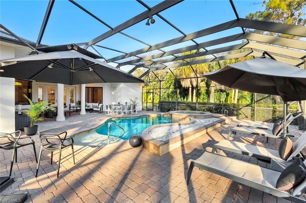 Combined pool / hot tub featuring a patio, a lanai, and a sunroom