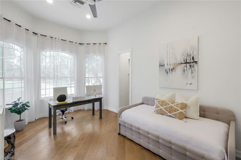 Bedroom featuring wood-type flooring, a desk, and ceiling fan