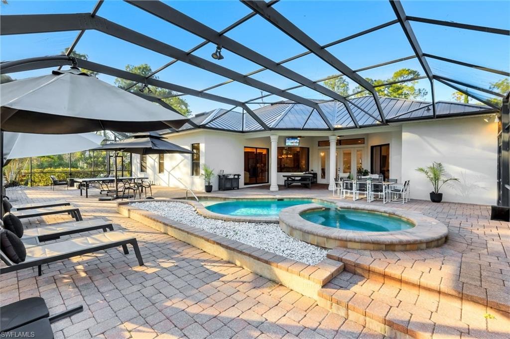 Integrated pool / hot tub featuring outdoor dining space, a lanai, a patio area, and a sunroom