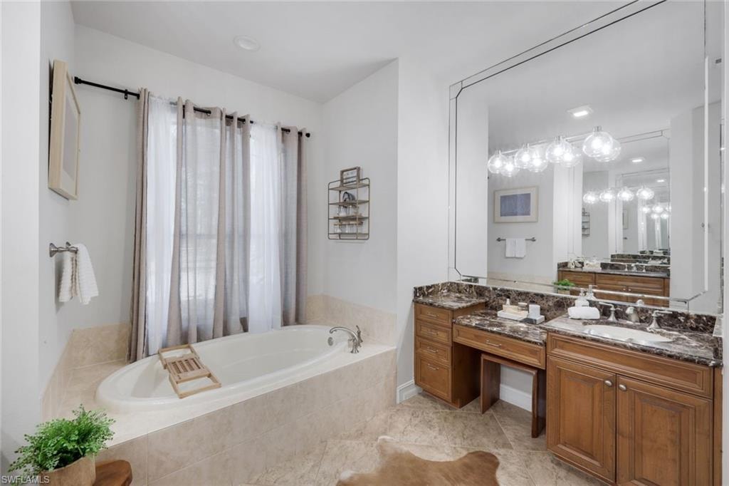Full bath featuring vanity and a bath