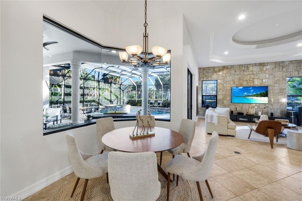 Dining space with suspended lighting and a raised ceiling