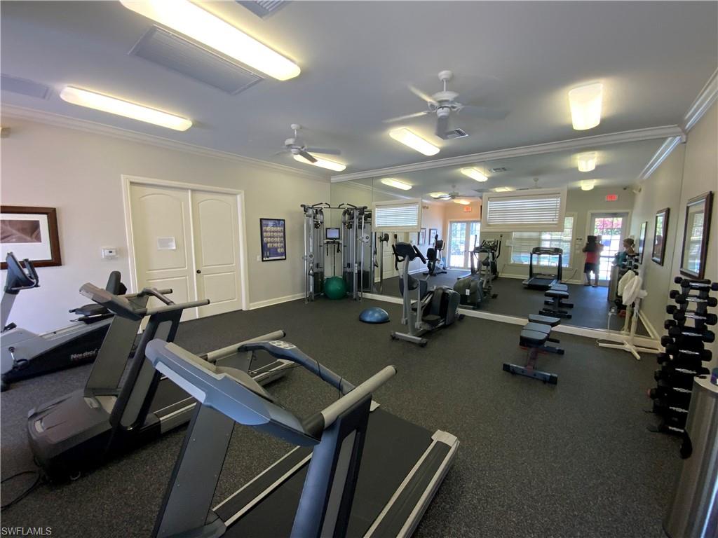 Workout area with a ceiling fan and ornamental molding