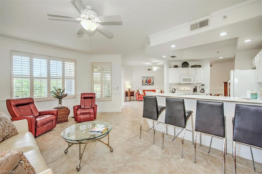 Living area featuring a ceiling fan, ornamental molding, recessed lighting, and light tile patterned floors