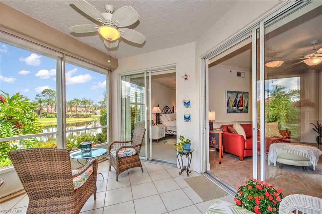 Sunroom with tile patterned flooring, a water view, and a textured ceiling