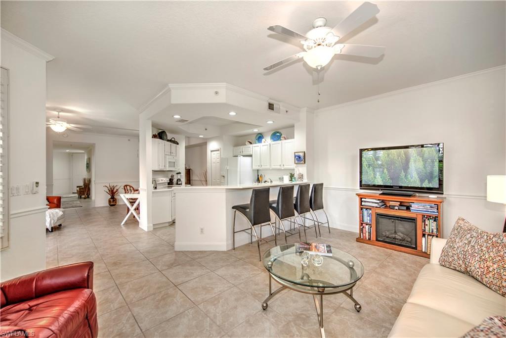Living room featuring ceiling fan, crown molding, recessed lighting, and light tile patterned floors