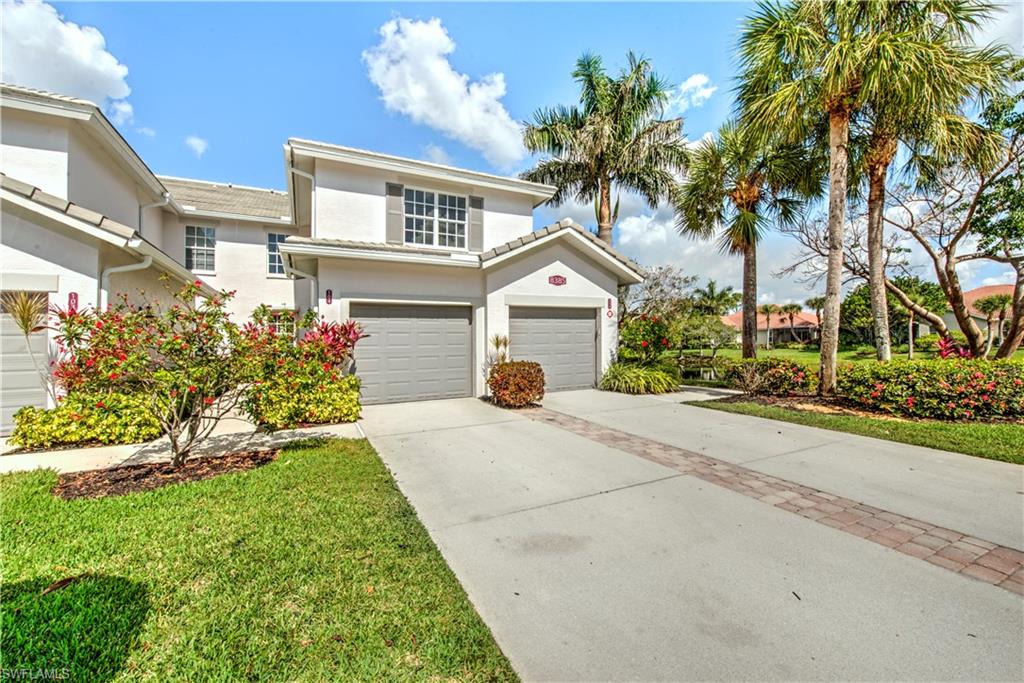 Traditional-style home with stucco siding, concrete driveway, an attached garage, and a front lawn