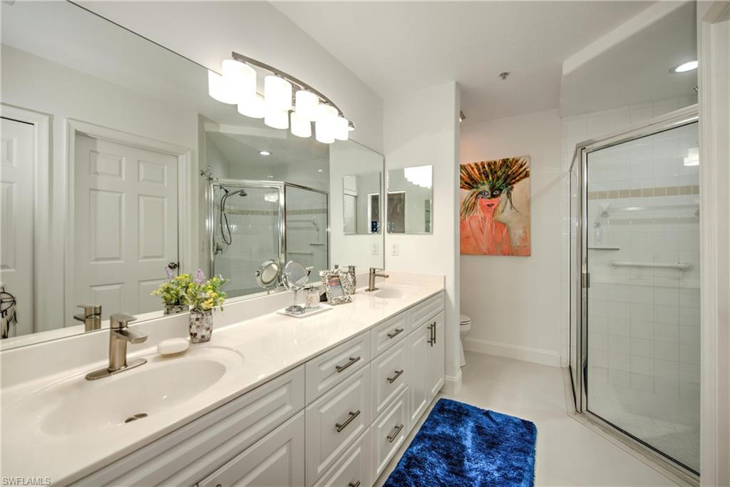 Bathroom featuring double vanity and a stall shower