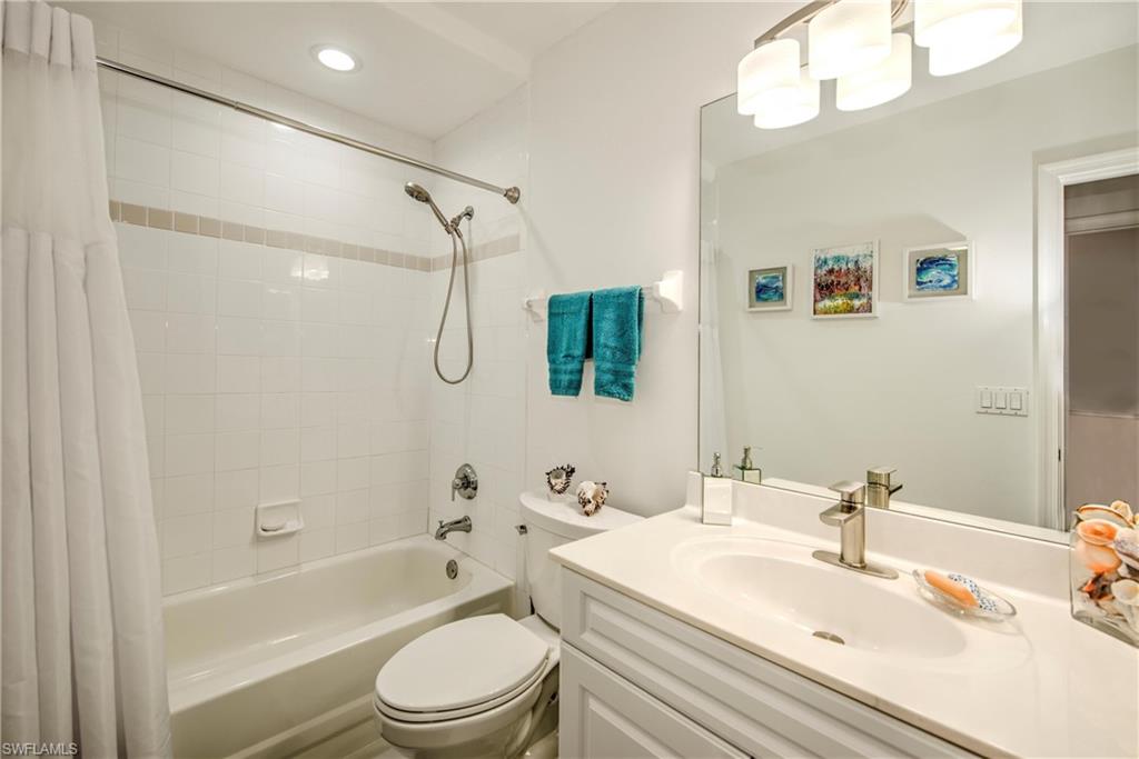 Bathroom featuring shower / bath combination with curtain and vanity
