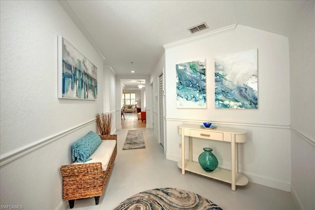 Hallway with ornamental molding and baseboards