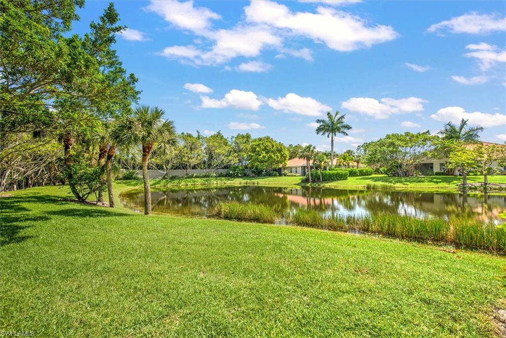 Surrounding community featuring a water view and a yard