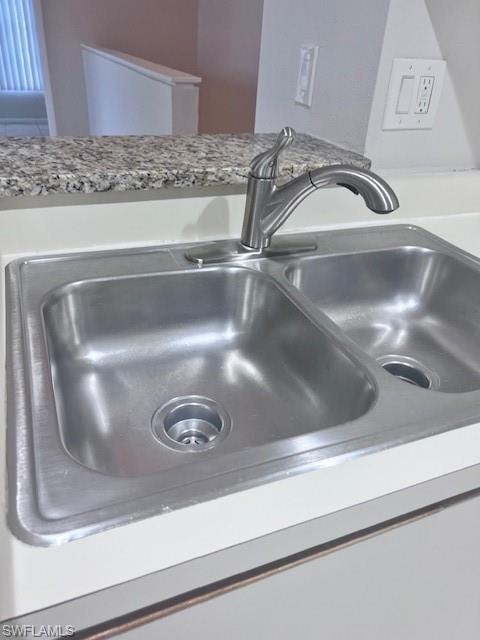 Kitchen view of a sink and light countertops