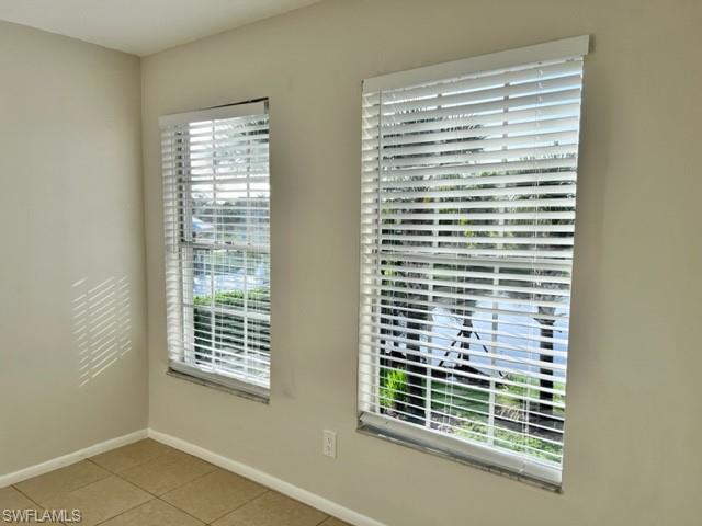 Unfurnished room featuring light tile patterned floors and baseboards