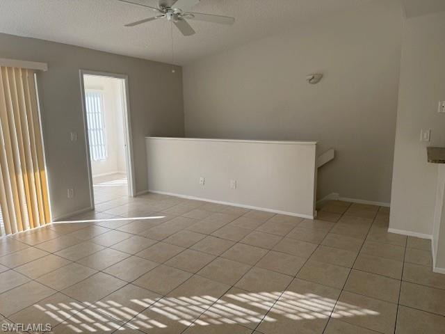 Unfurnished room with a textured ceiling, a ceiling fan, and light tile patterned flooring