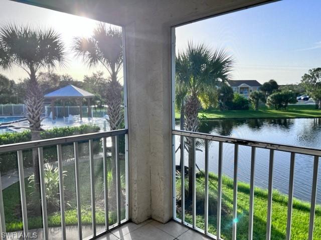 Balcony featuring a water view and a sunroom