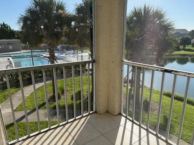 Balcony featuring a sunroom, a water view, and view of pool