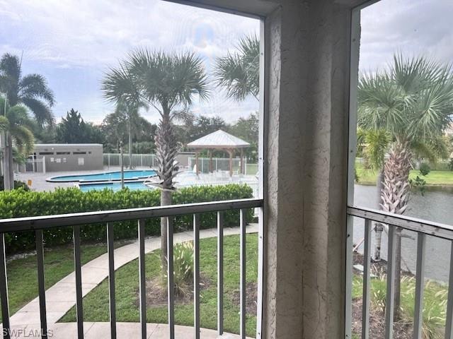 Balcony featuring view of pool and a gazebo