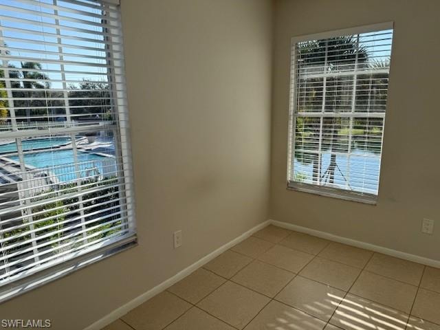 Unfurnished room with healthy amount of natural light and light tile patterned flooring