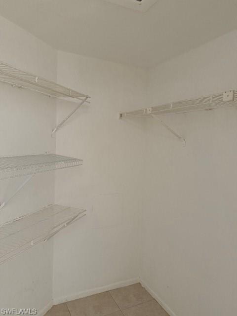 Spacious closet featuring light tile patterned flooring