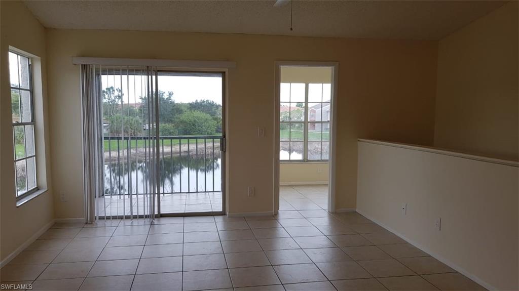 Empty room with a water view and light tile patterned flooring