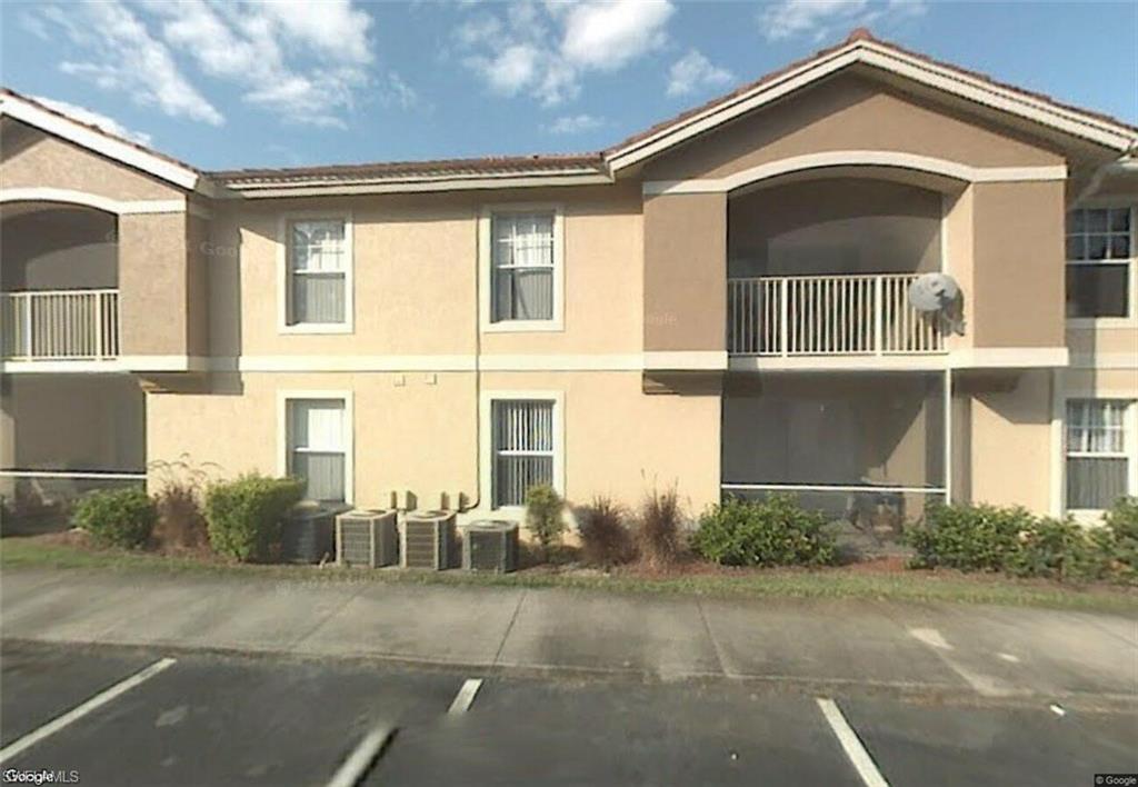 View of apartment building / complex featuring uncovered parking