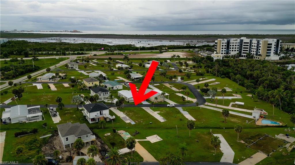 Aerial view of property and surrounding area featuring a nearby body of water and nearby suburban area