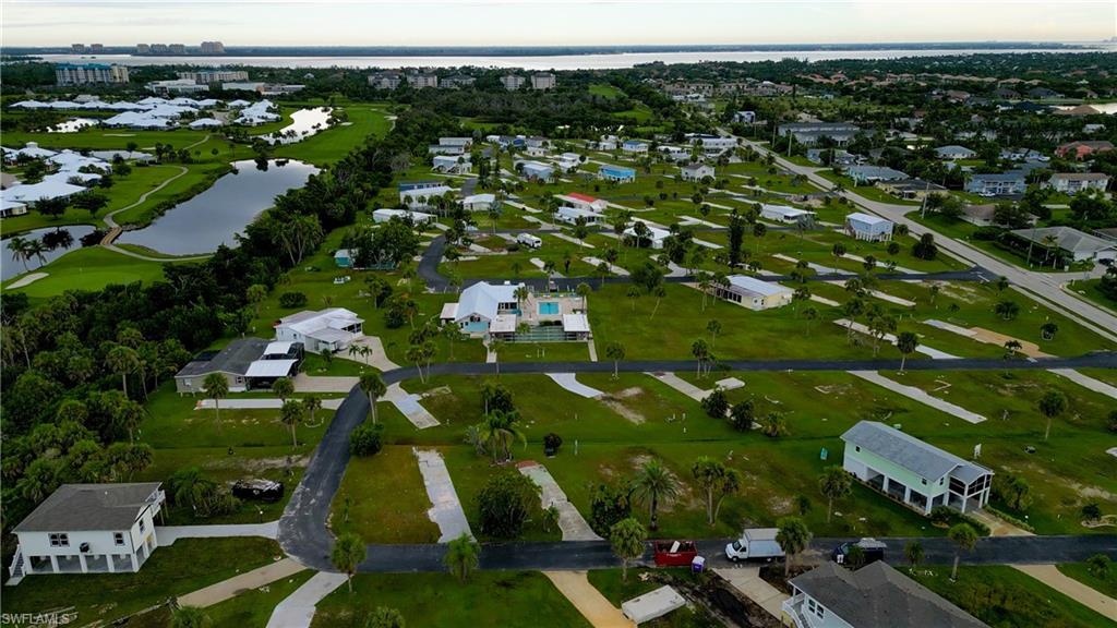 Aerial view of property and surrounding area featuring a large body of water and nearby suburban area
