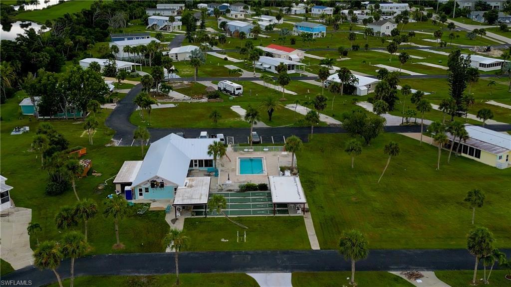 Aerial view of property and surrounding area with a nearby body of water and a pool area