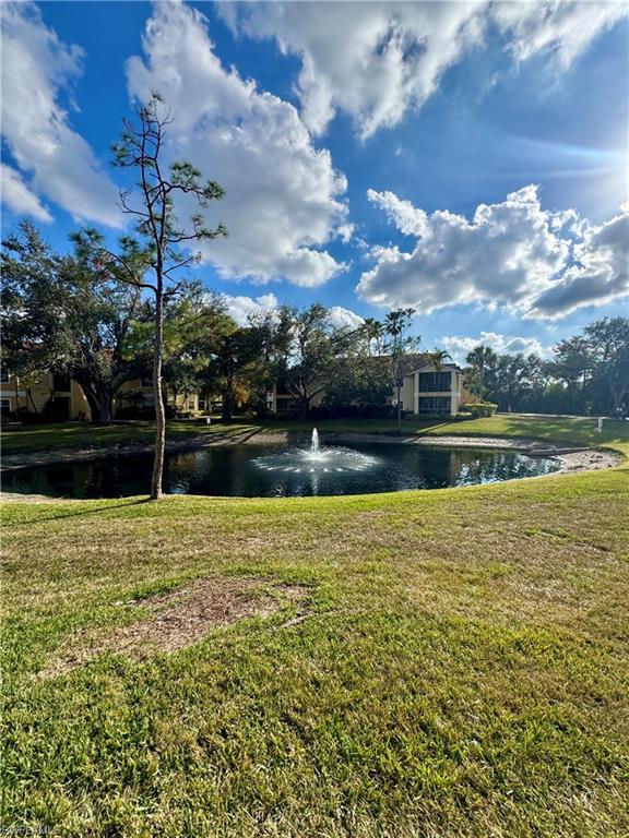 View of property's community featuring a water view and a yard