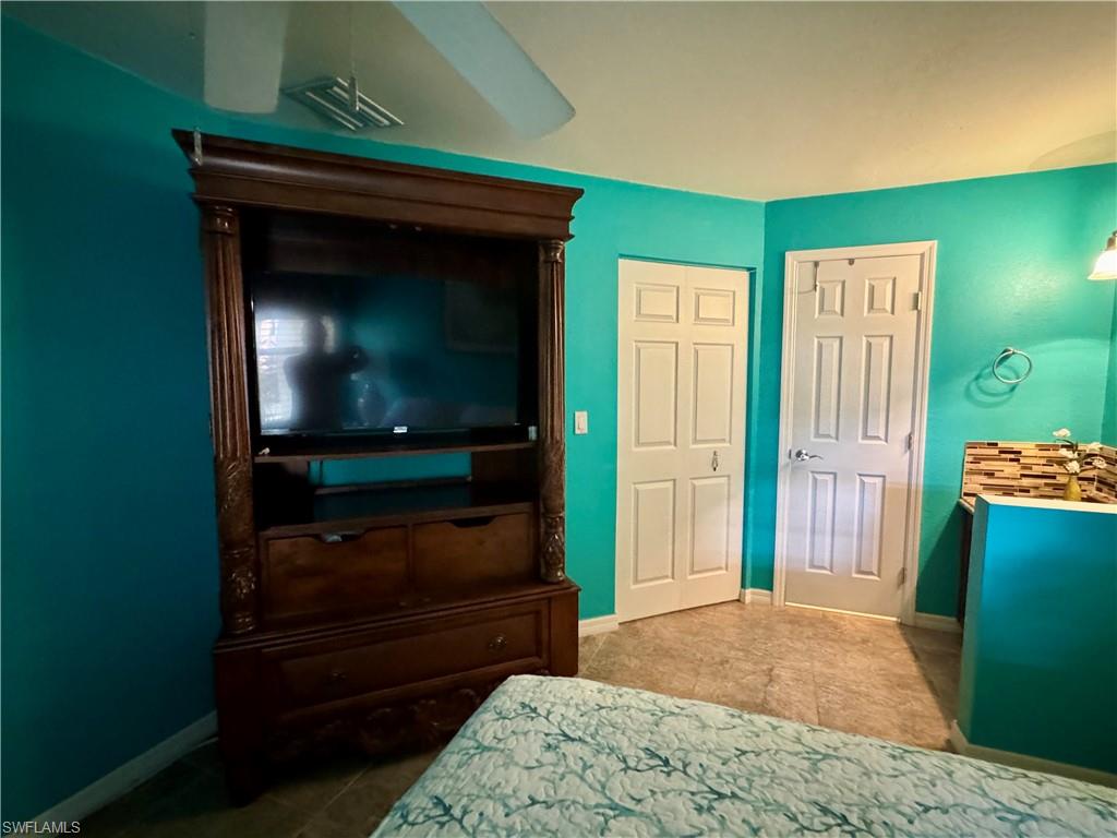 Bedroom featuring ceiling fan, a closet, and light tile patterned floors