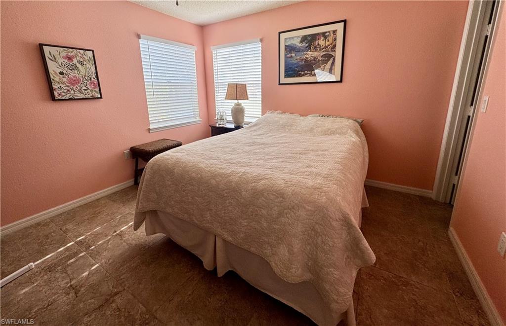 Bedroom featuring a textured wall and a textured ceiling