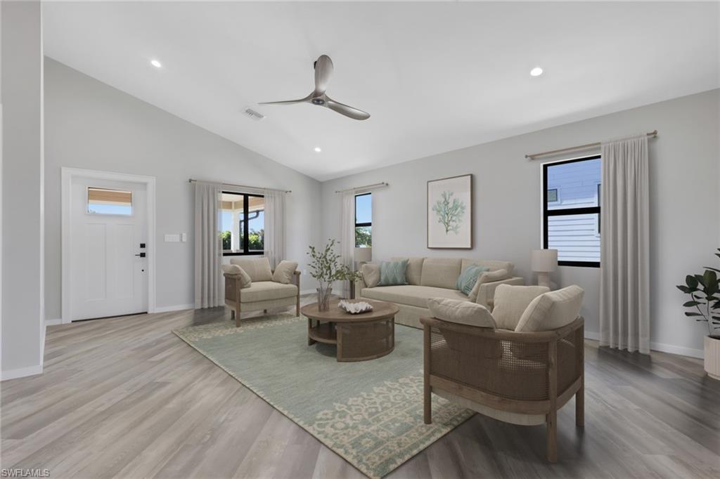 Living area with a ceiling fan, vaulted ceiling, light wood-style flooring, and recessed lighting