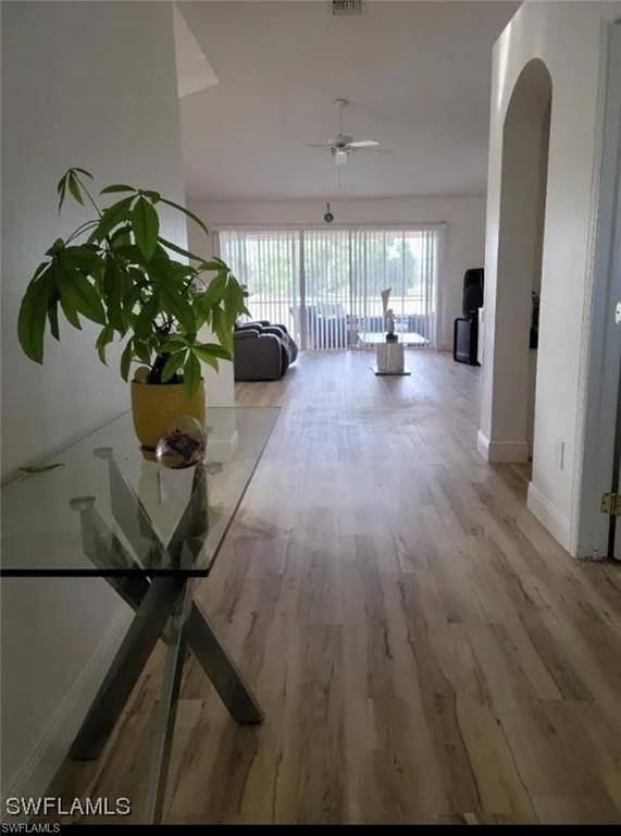 Hall featuring light wood-style flooring and arched walkways