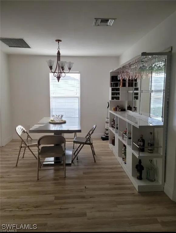 Dining room with light wood-style flooring and a chandelier