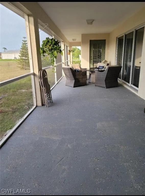 View of patio with a sunroom and outdoor lounge area