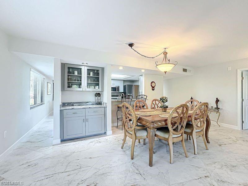 Dining area with light marble finish floors and baseboards