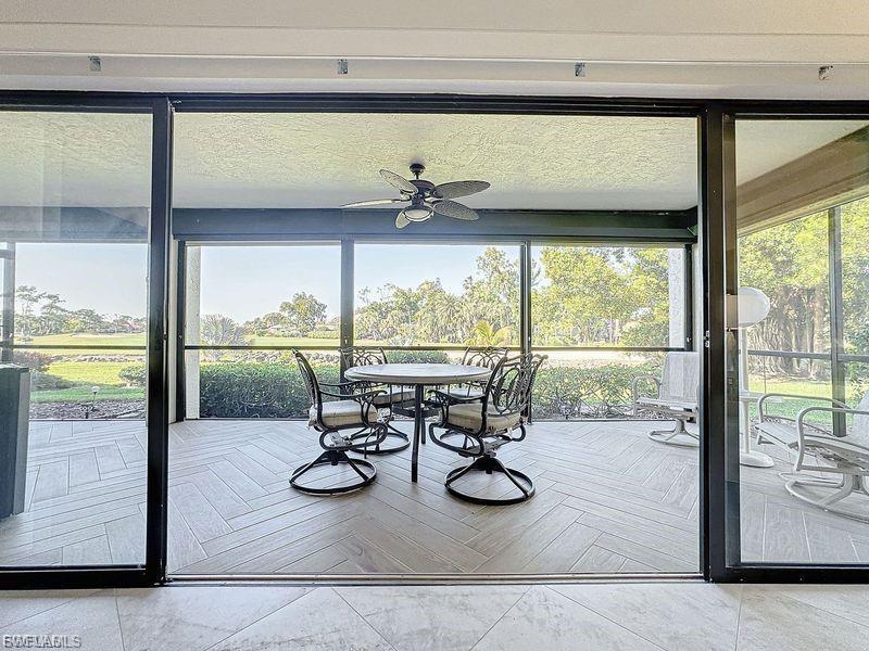 Sunroom / solarium featuring a ceiling fan and outdoor dining space