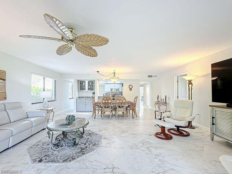 Living area with baseboards and ceiling fan