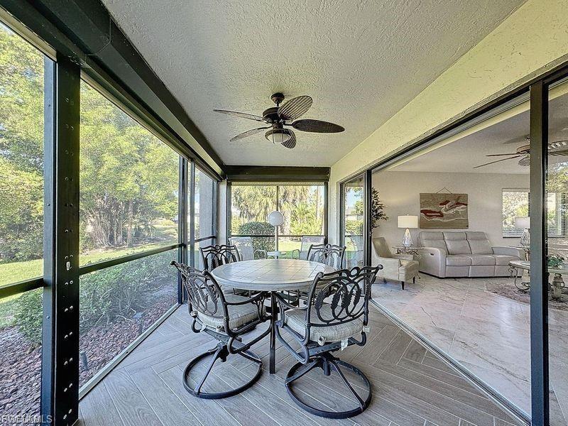 Sunroom / solarium with a ceiling fan and outdoor dining space