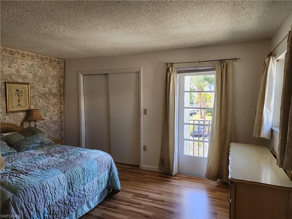 Bedroom featuring wood finished floors, a textured ceiling, and a closet