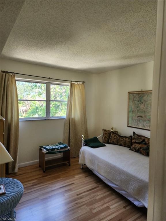 Bedroom featuring wood finished floors and a textured ceiling