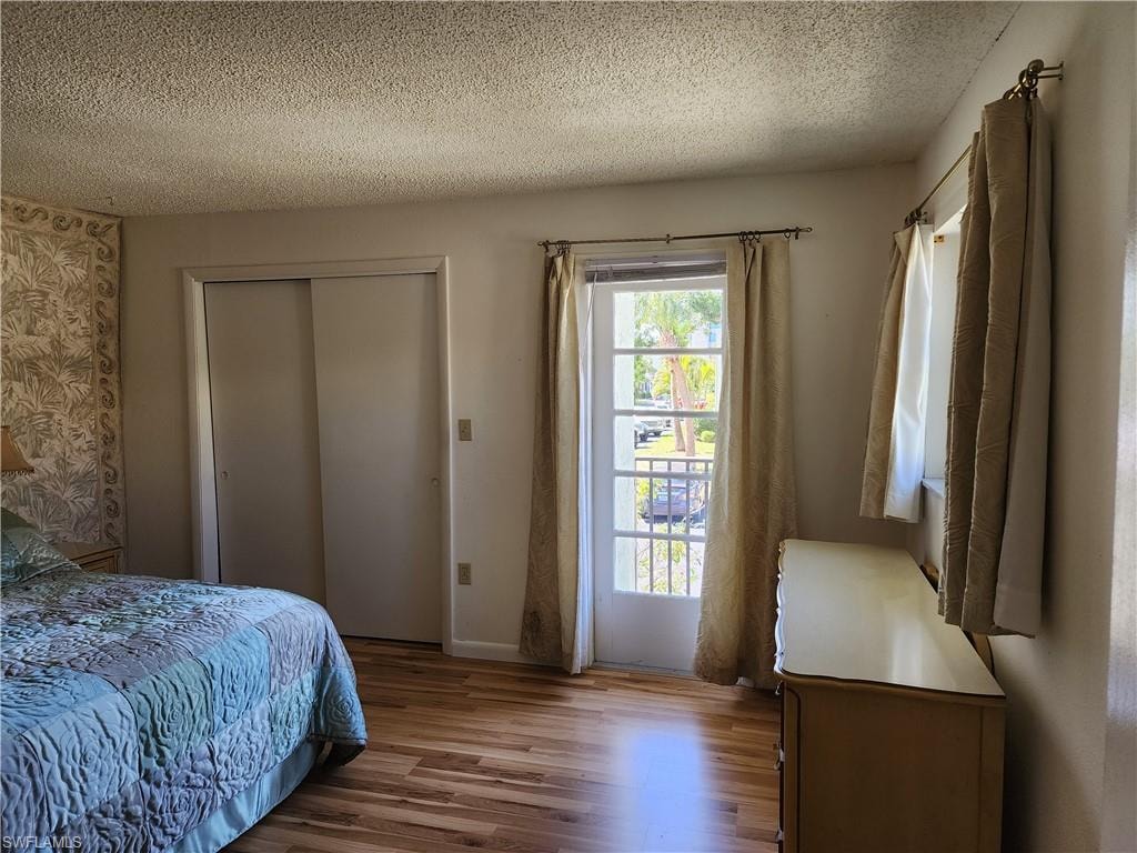 Bedroom featuring wood finished floors, a textured ceiling, and a closet
