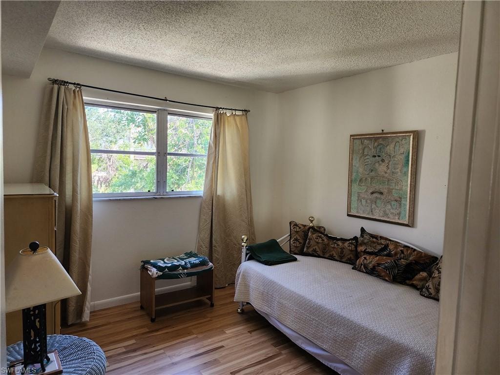 Bedroom featuring wood finished floors and a textured ceiling