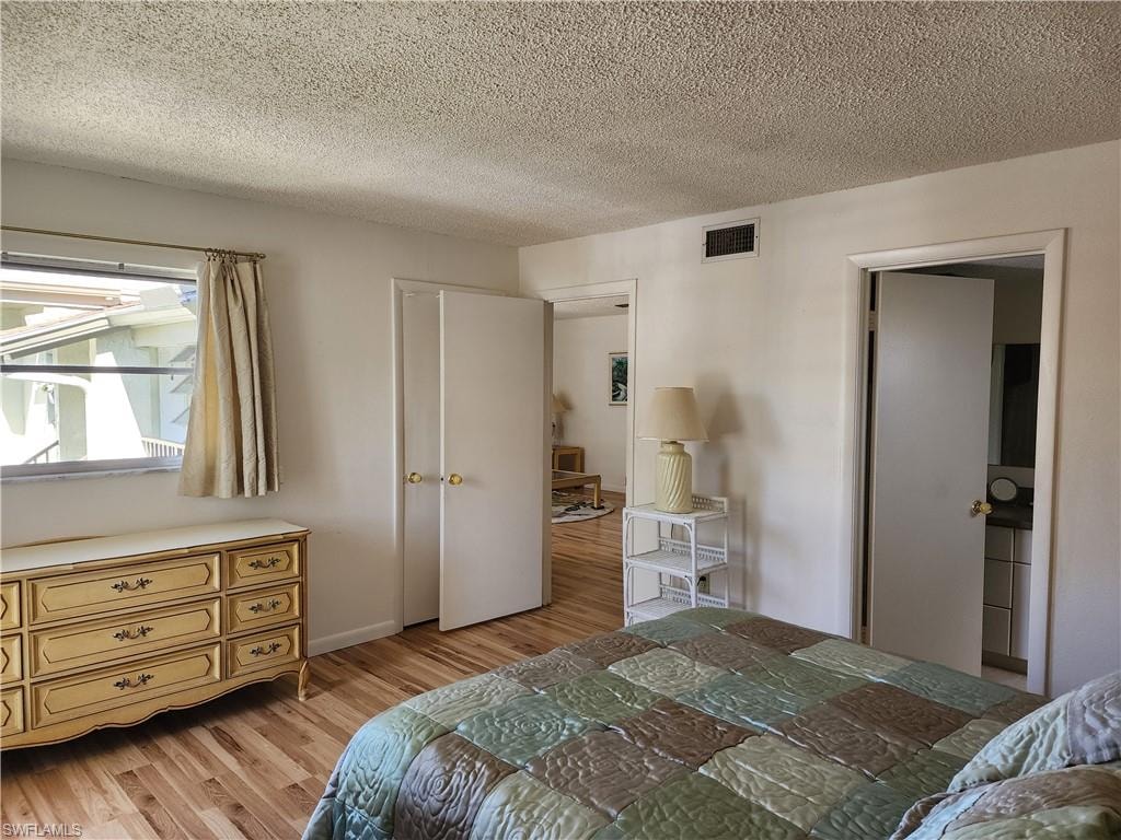 Bedroom featuring light wood finished floors and a textured ceiling