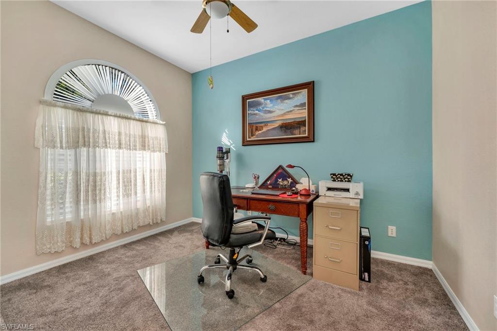 Carpeted office/den space featuring ceiling fan