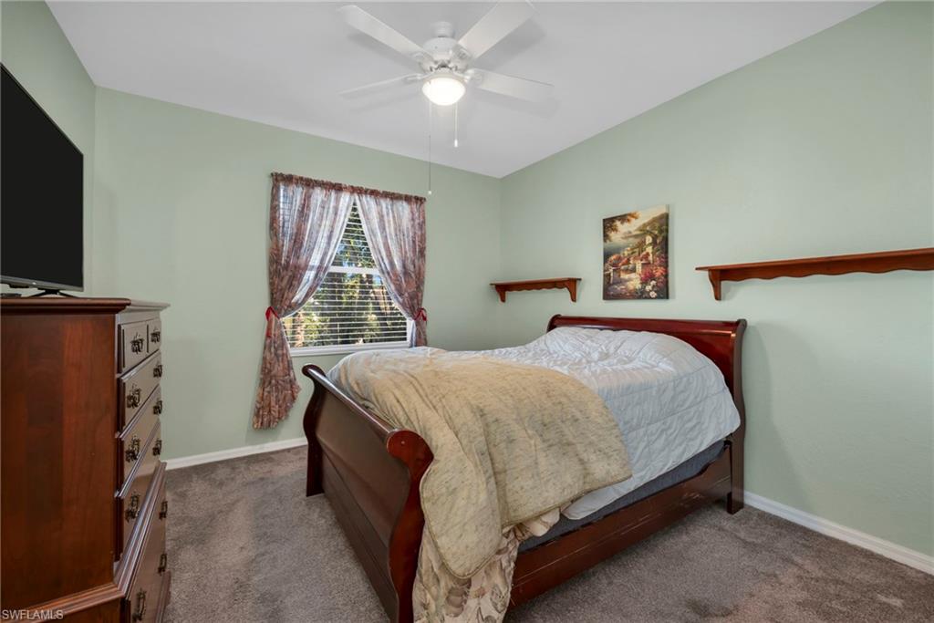 Carpeted bedroom with a ceiling fan