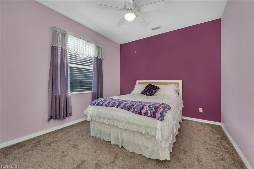 Carpeted bedroom with a ceiling fan