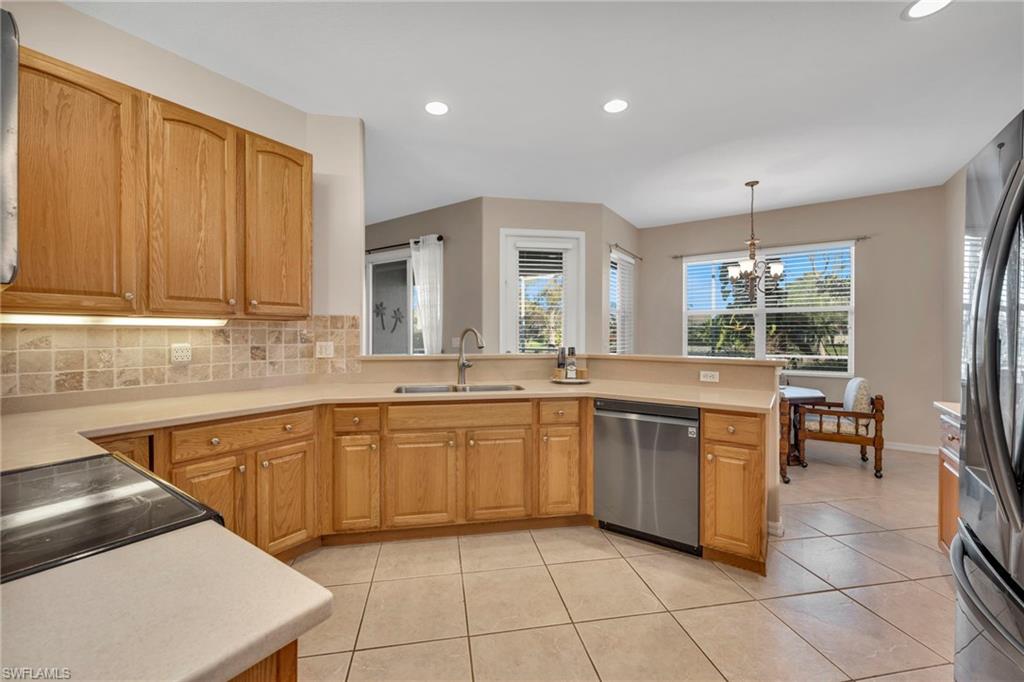 Kitchen featuring tasteful tile backsplash, light countertops, stainless steel appliances, recessed lighting and light tile patterned flooring