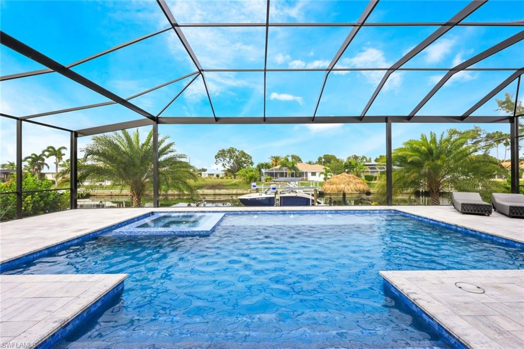 Swimming pool featuring a water view, a lanai, a patio, an in-ground hot tub, and a sunroom